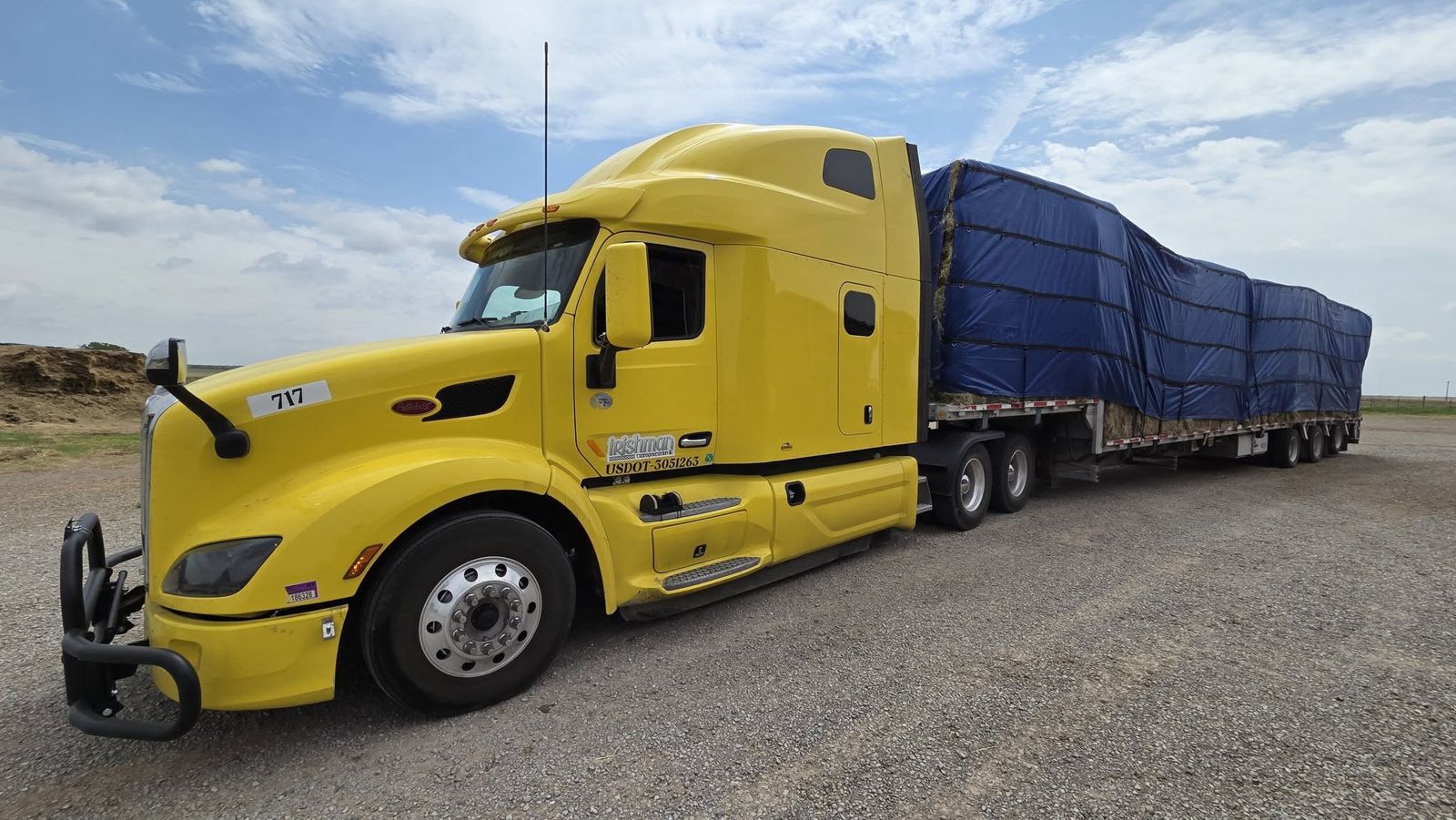 Our yellow 2020 Peterbilt 579 with a fully tarped load, covered from weather and road spray.